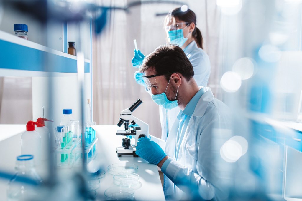 Doctor in the laboratory analyzes samples of codiv-9 under a microscope